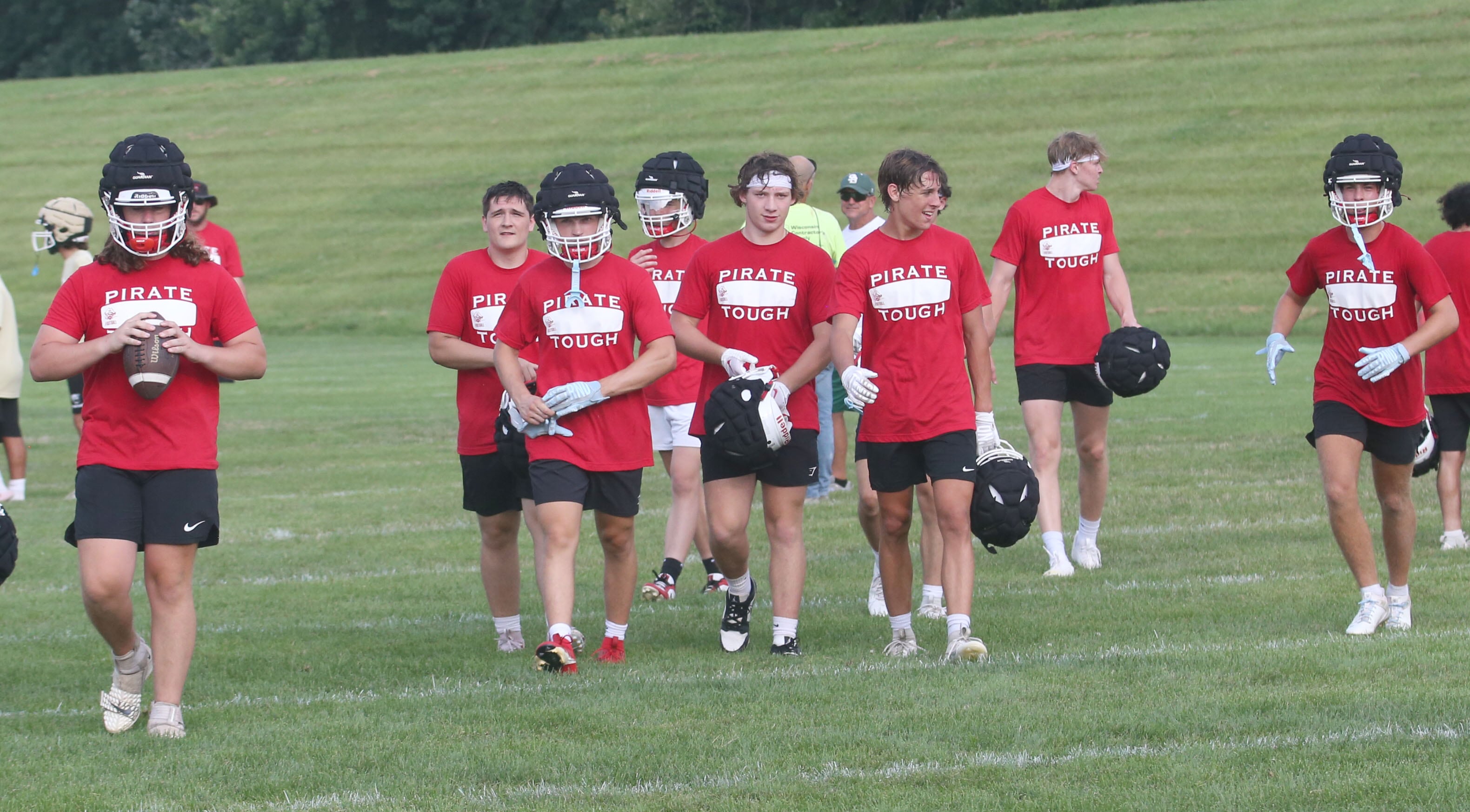 Members of the Ottawa football team walk off of the field after a 7-on-7 scrimmage against St. Bede in mid-July at Ottawa High School.