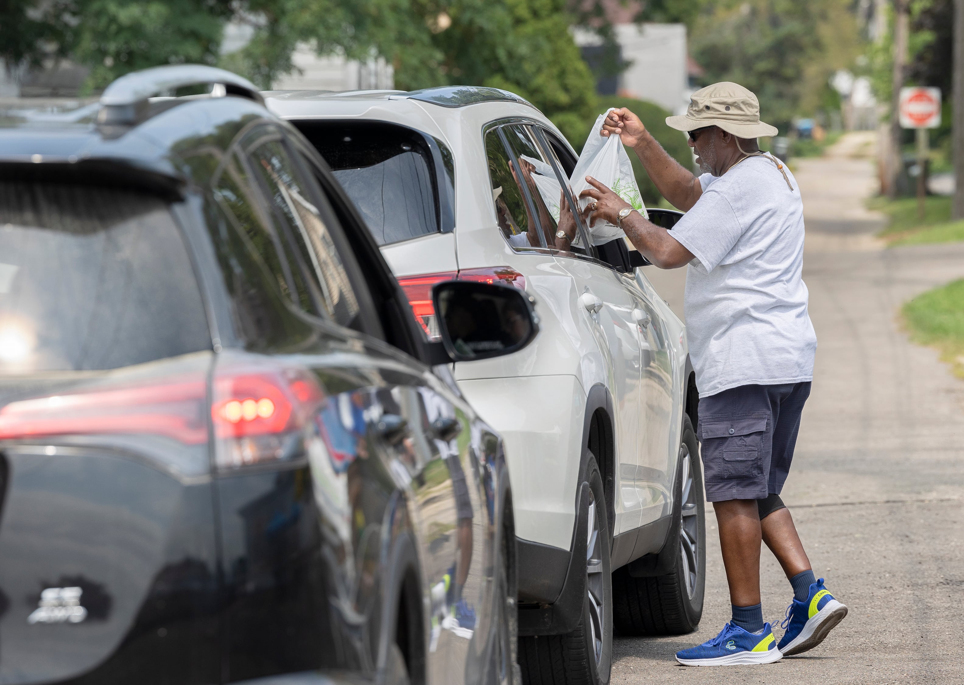 Gordon Harris, chaplain for Post 296, delivers meals to waiting cars Monday, Aug. 5, 2024 in Sterling.