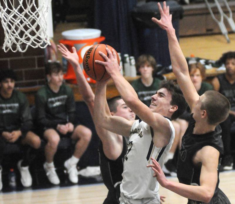 Marquette's Denver Trainor shoots past two Midland defenders at Bader Gym on Friday, Jan. 19, 2024.