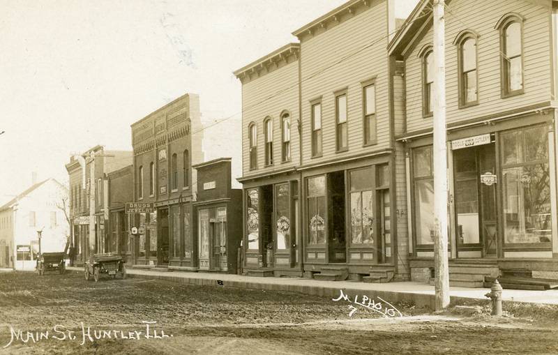 A historic photo of Main Street in Huntley. Patrick Michael Jewelers is located in the building with a sign reading "drugs and jewelry", which was once home to a jewelry store