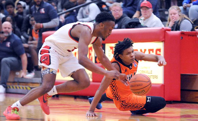 Yorkville's Dayvion Johnson (left) and Romeoville's Ej Mosley, Jr. chase a loose ball during a varsity basketball game at Yorkville High School on Friday, Jan. 19, 2024.