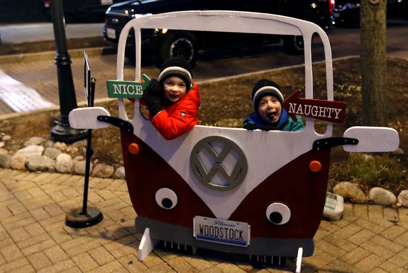 Jack, 6, and Luke Nenni, 4, of Woodstock, wait for their dade, Nick to take their photograph during the Lighting of the Square Friday, Nov. 24, 2023, in Woodstock. The annual holiday season event featured brass music, caroling, free doughnuts and cider, food trucks, festive selfie stations and shopping.