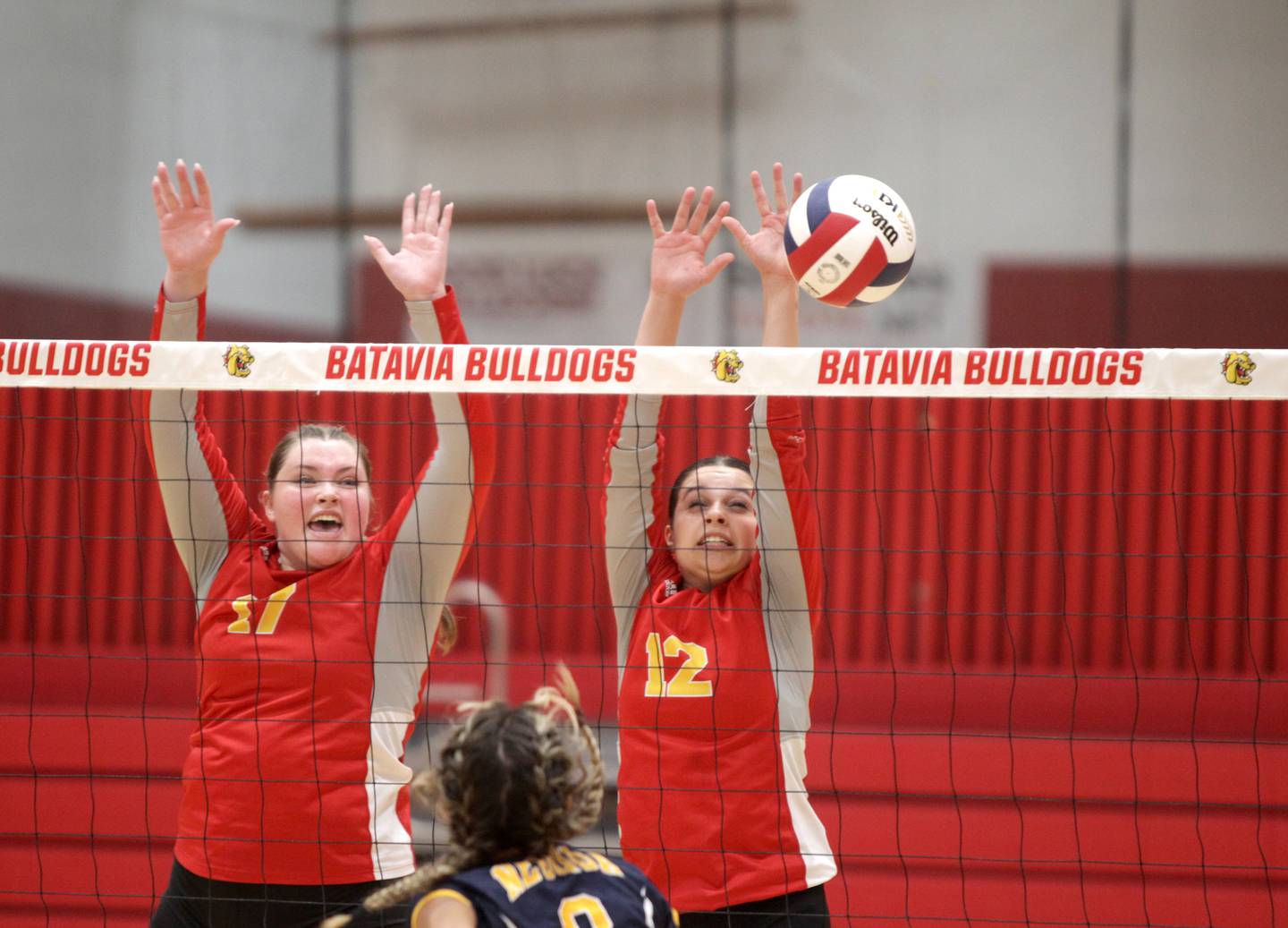 Batavia’s Brooke Robertson (left) and Zoe Balzanto (right) go up for a block during a home game against Neuqua Valley on Tuesday, Aug. 29, 2023.