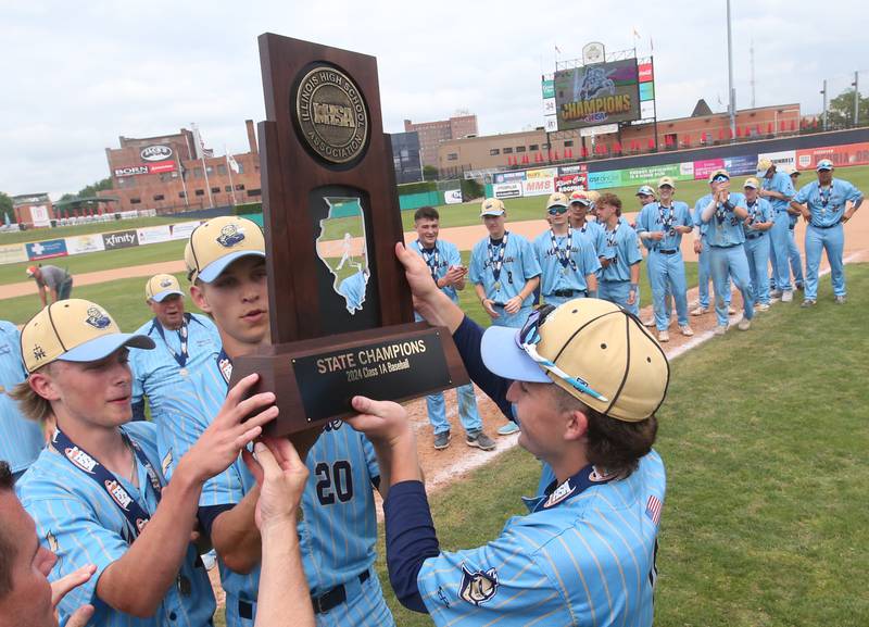 Marquette players Ryan Peterson, Charlie Mullen and Carson Zellers hoist the Class 1A championship baseball trophy after defeating Altamont 6-2 on Saturday, June 1, 2024 at Dozer Park in Peoria.