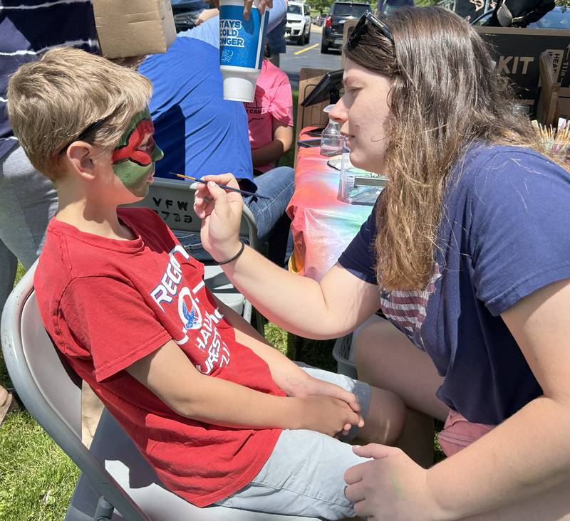 Sebastian Murphy, 8, of Oregon, has his face painted by McKenzie Alford during the Oregon VFW's Memorial Day event on Monday, May 27, 2024. Alford was helping face painter Ashlynn Whaley at the event.