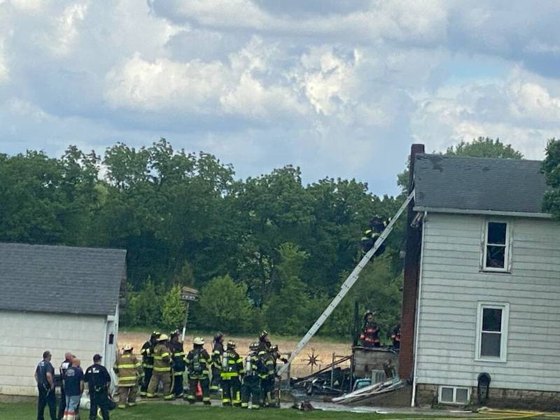 Firefighters responded to a house fire Tuesday, May 28, 2024, on South Hossack Street in Seneca. A firefighter climbs up a ladder to investigate the home and ensure the fire is fully extinguished throughout the house.