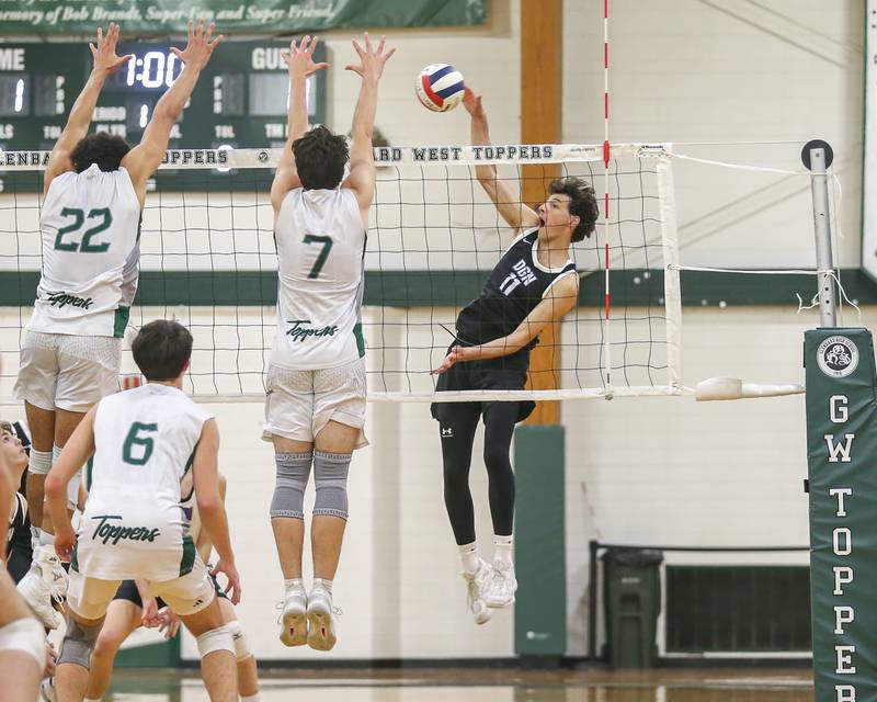 Downers Grove North's Aidan Akkawi (11) spikes the ball during volleyball match between Downers Grove North at Glenbard West.  April 2, 2024.