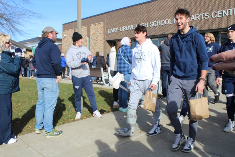 Cary-Grove football team walks past friends, family and friends as they board the bus to the state championship game Friday.