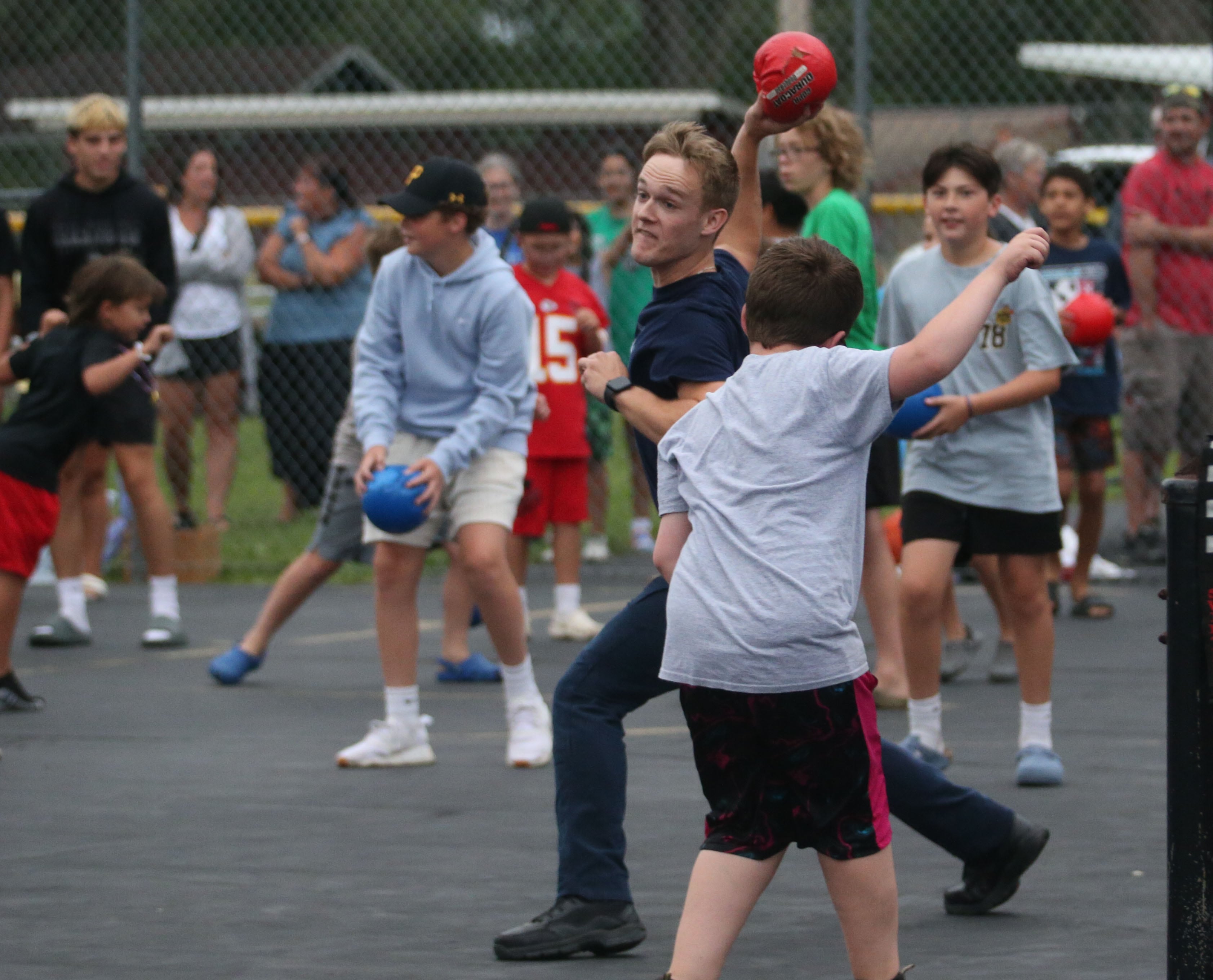 EMT Dylan Macklin with 1033 Ambulance, throws a dodge ball at Spring Valley Firefighters during a game of kids versus first responders during  the National Night Out event on Tuesday, Aug. 6, 2024 at Kirby Park in Spring Valley.