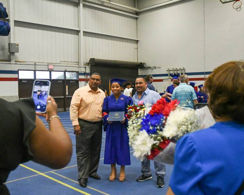 Graduate Sanela Allen poses for a photo wither stepdad Dereck Caldwell, left, and father Tom Allen after graduating from Glenbard South High School on Thursday May 23, 2024, held at Glenbard South High School's gymnasium.