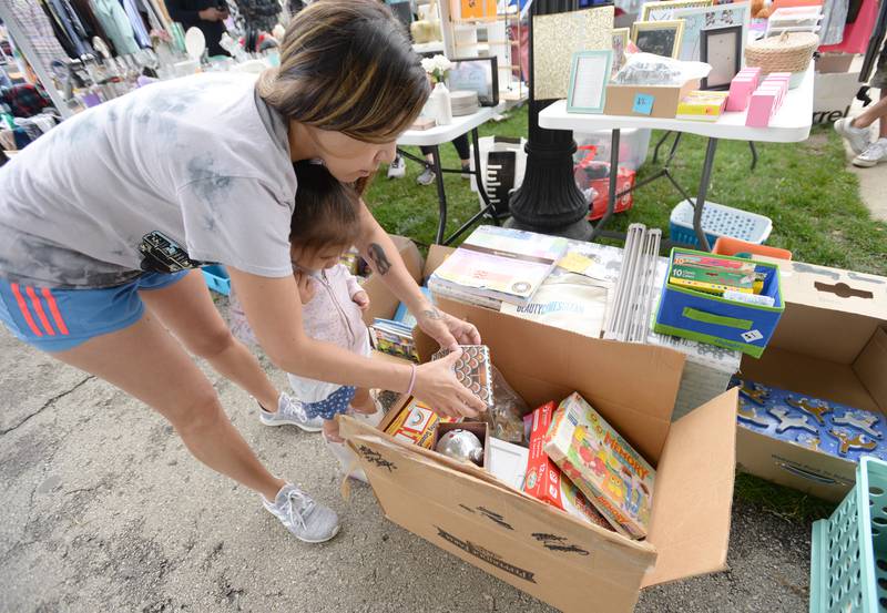 Brian Fron and her mom Teresa Vasquez of Berwyn look at some of the children items during the Berwyn Garage Sale held Saturday July 8, 2023.