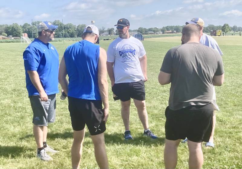 Kirk Becker, a 2003 PHS alum, huddles up with the Tiger coaching staff at the end of their mini-camp in June. Becker has joined the staff as defensive line coach.