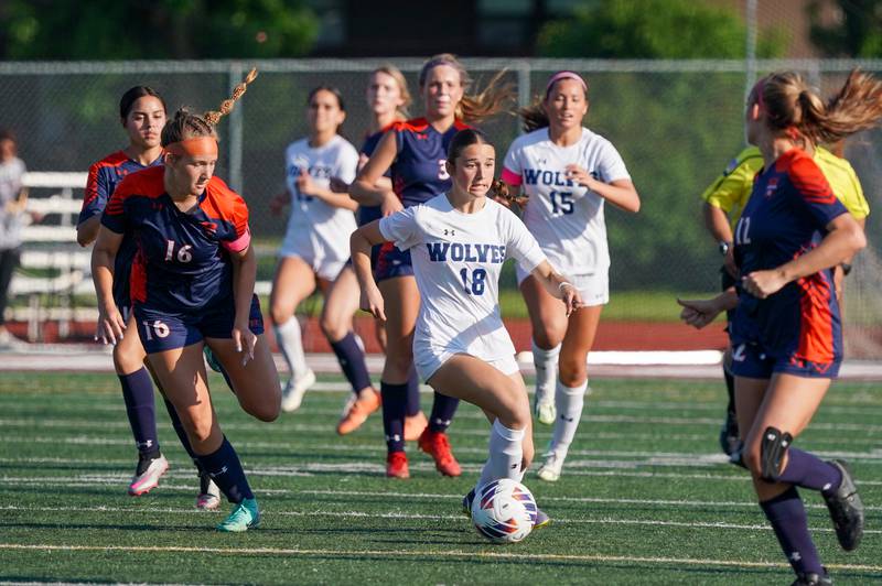 Oswego East's Ashley Gumm (18) plays the ball against Oswego’s Peyton Johnson (16) during a Class 3A Lockport Regional semifinal soccer match at Lockport High School in Lockport on Wednesday, May 15, 2024.