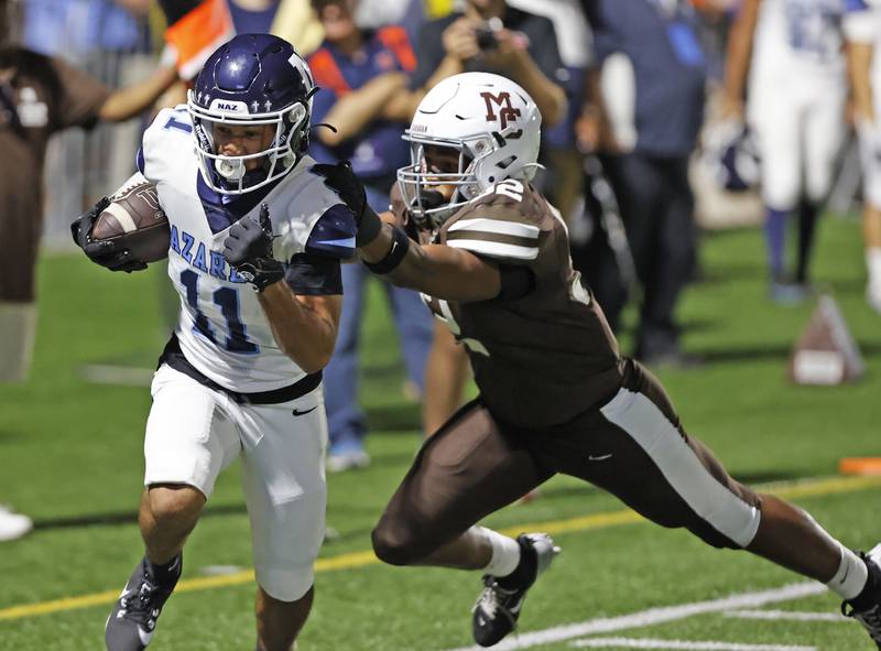 Nazareth's James Penley (11) tries to break away from the Mt. Carmel defense during the varsity football game between Nazareth Academy and Mt. Carmel high school on Friday, Sep. 13, 2024 in Chicago.