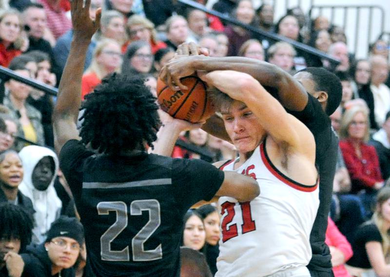 Yorkville's Taelor Clements gets fouled by two pressing Oswego East defenders during a varsity basketball game at Yorkville High School on Friday, Feb. 9, 2024.