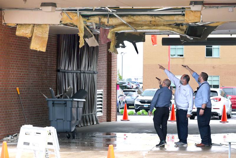 Northwestern Medicine Valley West Hospital employees inspect the damage in the ambulance bay after a truck too tall for the clearance tried to drive through it Tuesday, May 7, 2024, at the hospital in Sandwich. There was visible damage to the ceiling of the bay with insulation a wall material hanging down.