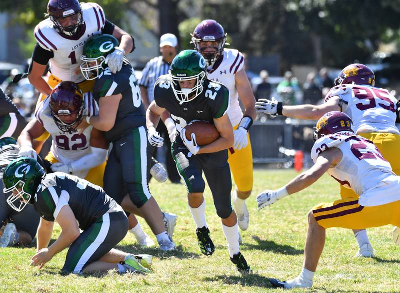 Glenbard West's Cooper Kinney (23) breaks through a hole in the Loyola Academy defense during a game on September 7, 2024 at Glenbard West High School in Glen Ellyn.