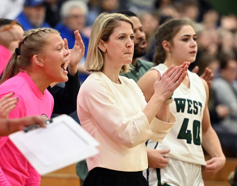 Glenbard West coach Kristi Faulkner and players on the bench celebrate a call that went the Hilltoppers’ way during the Glenbard West Class 4A girls basketball regional final on Thursday, Feb. 15, 2024 in Glen Ellyn.