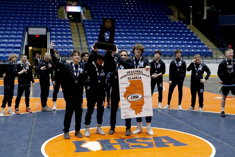 Wrestlers from Marina Central raise their first place trophy after defeating Coal City in the IHSA Class 1A Dual Team Sate Championship on Saturday, Feb. 24, 2024 at Grossinger Motors Arena in Bloomington.