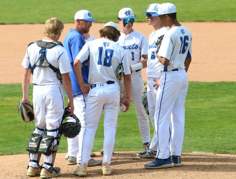 Newman head coach Kenny Koerner talks to his team on the mound during the Class 2A semifinal game on Friday, May 31, 2024 at Dozer Park in Peoria.