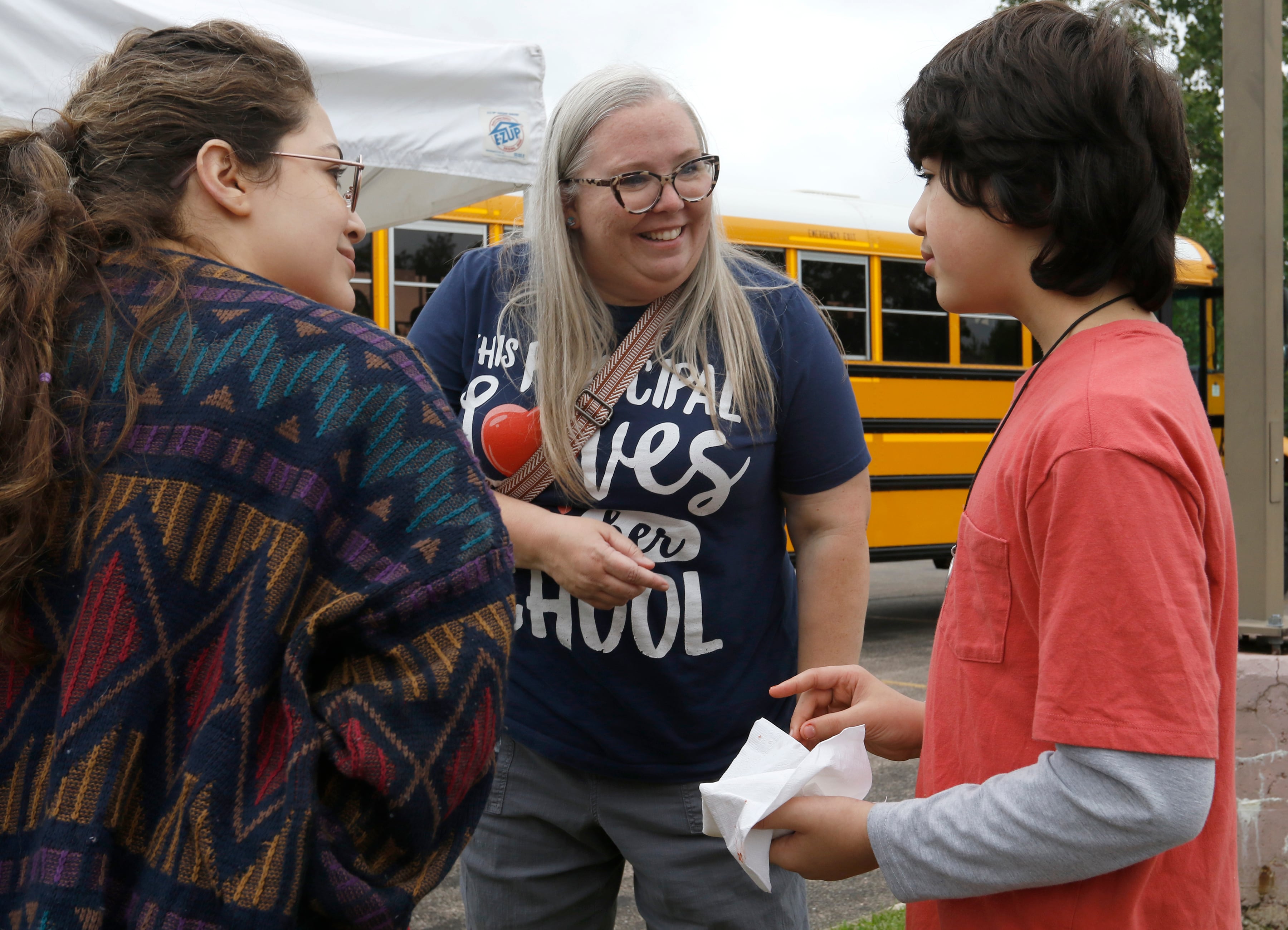 Northwood principal Bethany Hall talks with Ian Mejdouli and his mom, Tavena, during a Woodstock School District 200 Back to School Coming to You event at Sheila Street Apartments on Tuesday, Aug. 6, 2024. The location was one of twelve stops on the tour that gave out backpacks and school supplies, provided registration help and computer repair.