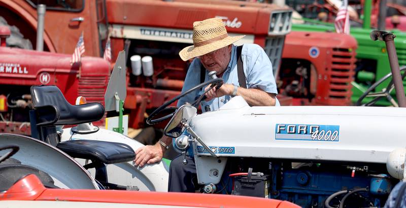 Marvin Marquardt of Marengo climbs aboard his 1964 Ford 4000-series tractor at the McHenry County Fair in Woodstock on Tuesday, July 30, 2024.