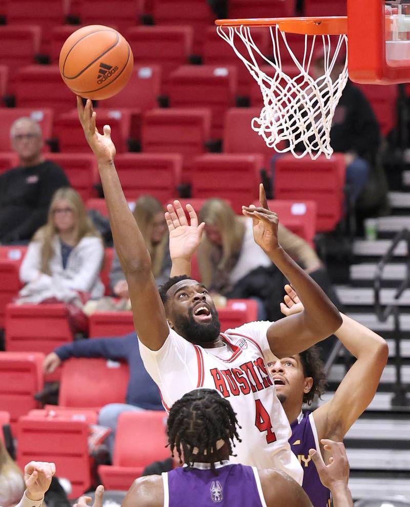 Northern Illinois Huskies forward Oluwasegun Durosinmi goes to the basket between three Albany defenders during their game Tuesday, Dec. 20, 2022, in the Convocation Center at NIU in DeKalb.