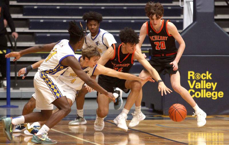 McHenry’s Adam Anwar, center, and Marcus Honea, right, battle a host of Warren Blue Devils  during IHSA Class 4A Sectional Final action at Rock Valley College on Friday night.