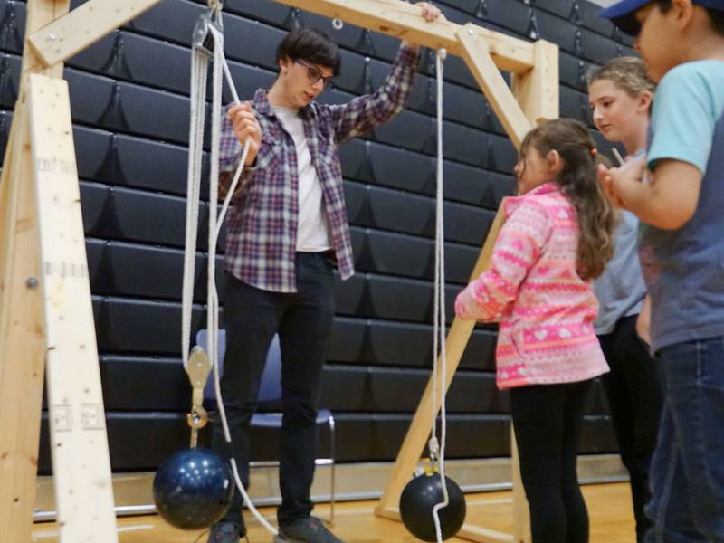 Donovan Maltas demonstrates weight distribution using a pulley system with bowling balls on Friday, April 19, 2024, at Illinois Valley Community College's SciFest in Oglesby.