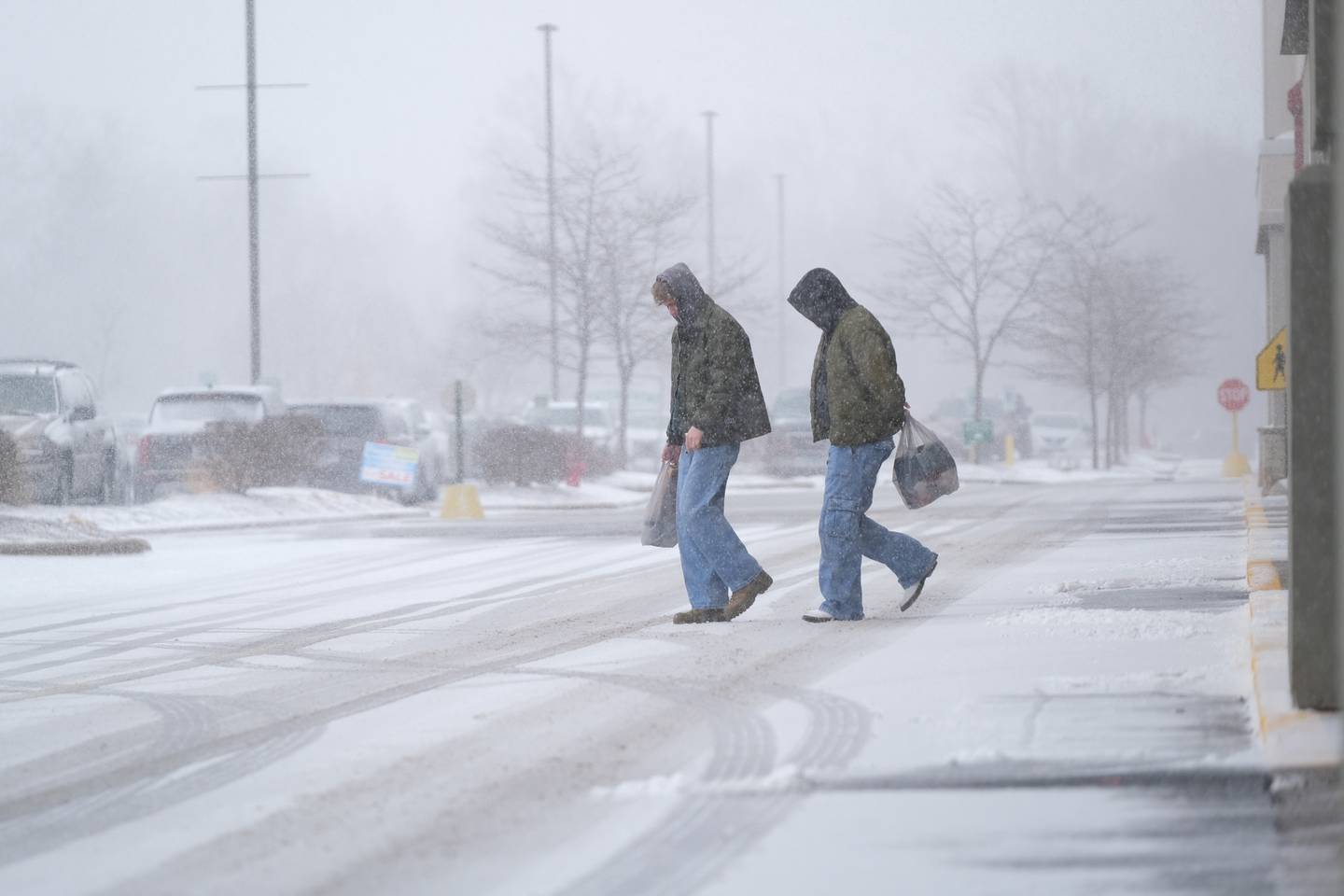 Shoppers leave a store as the snow falls at Louis Joliet Pointe Shopping Center. Thursday, Feb. 17, 2022, in Joliet.