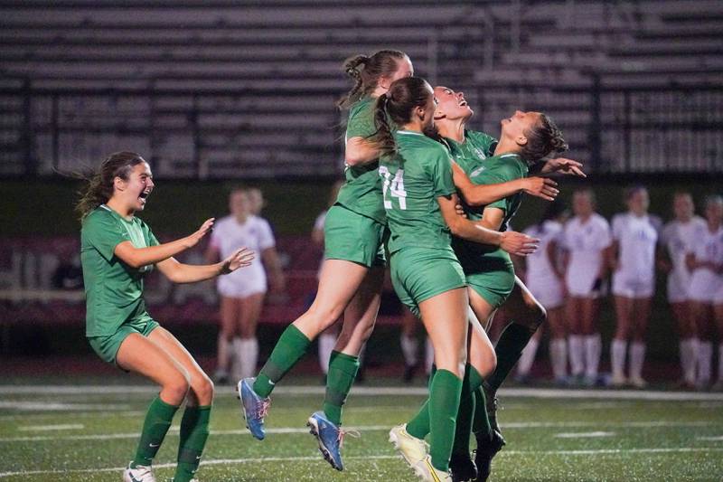 York’s players hug Cate Carter (right) after she scores the game winning goal off of a penalty kick during a Class 3A Hinsdale Central Sectional semifinal soccer match against Downers Grove North at Hinsdale Central High School in Hinsdale on Tuesday, May 21, 2024.