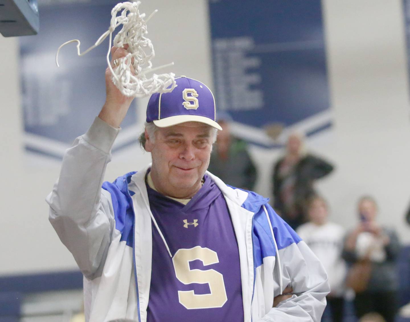 Serena High School athletic director Dean DeRango cuts down the net after the Huskers won the Little Ten boys basketball tournament championship this past February at Somonauk High School.