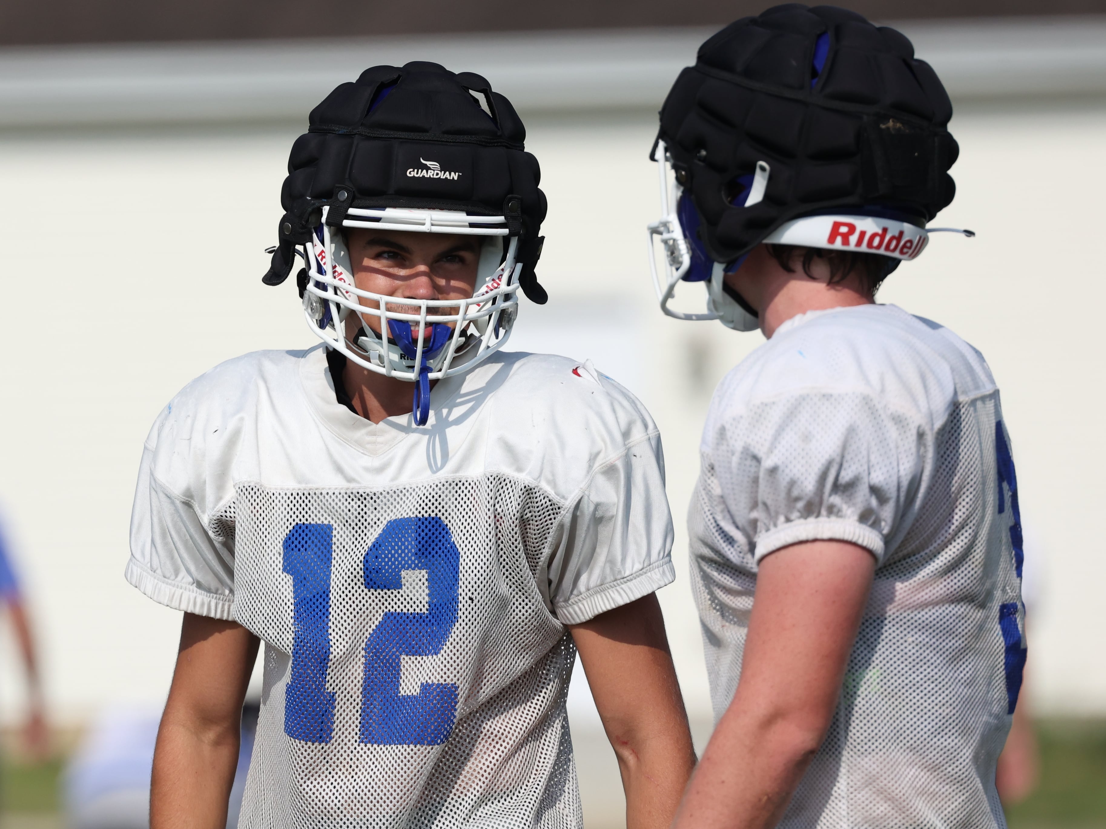 Genoa-Kingston’s John Swineheart (right) talks to a teammate during a break in practice Wednesday, Aug. 14, 2024, at the school in Genoa.