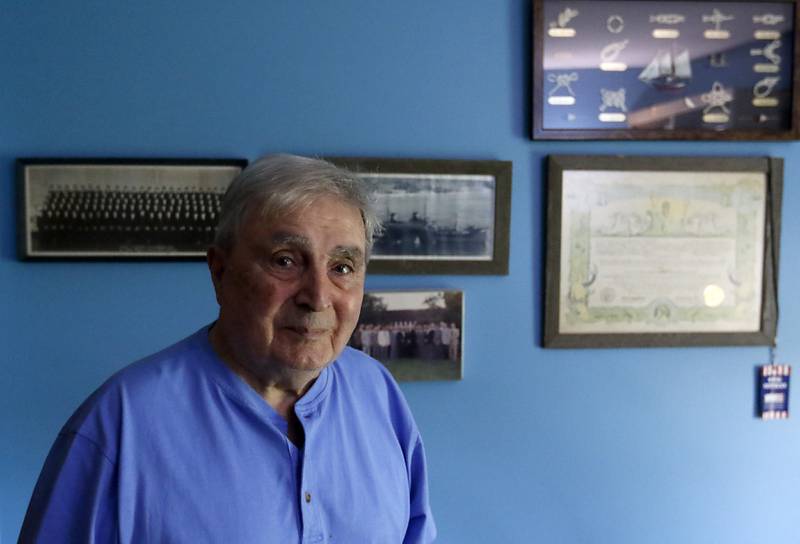 World War II United States Navy veteran Daniel Obriot who recently celebrated his 100th birthday in front of some of his Navy related photographs and memorabilia.