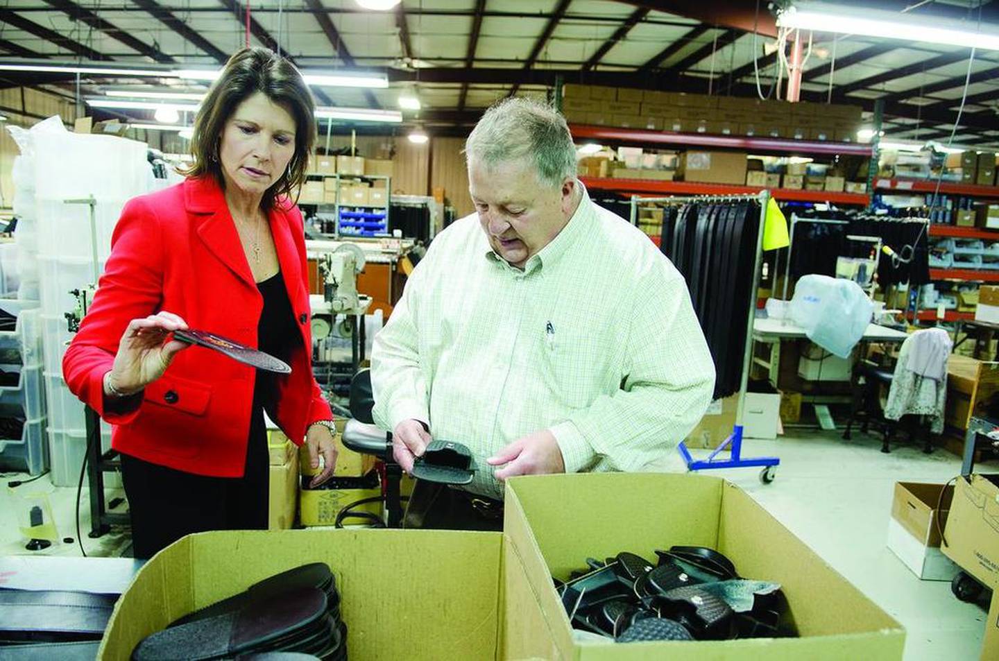 Bustos checks out Boston Leather products with company owner and founder Tony Valentino Monday afternoon. The company makes specialty leather products such as belts, wallets, cellphone holders and radio straps that Bustos said are ripe for the export market.