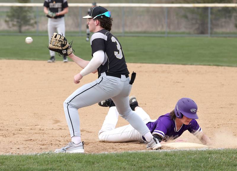 Rochelle’s Brock Metzger slides in safely on a pickoff attempt as Sycamore's Davis Collie fields the throw during their game Wednesday, April 10, 2024, at Rochelle High School.