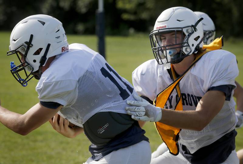 Charlie Ciske (right) tackles Peyton Seaburg during football practice Tuesday, Aug. 20, 2024, at Cary-Grove High School, as the 2023 IHSA Class 6A champions look to defend their title.