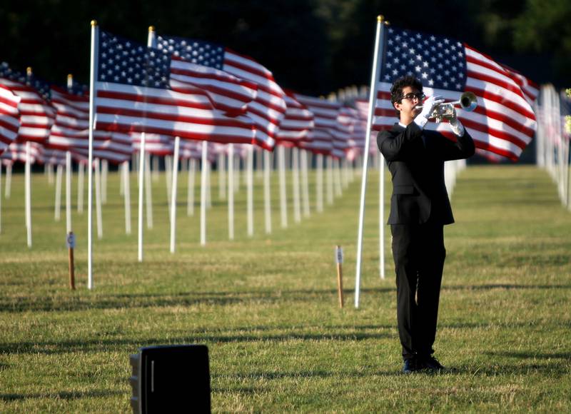 Deven Rea plays Taps during the opening night of the Field of Honor at Seven Gables Park in Wheaton on Saturday, June 29, 2024.