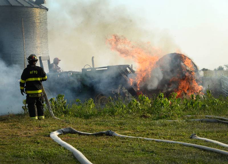 Lyle Hopkins of rural Polo uses a John Deere tractor to move a burning round bale of hay away from a machine shed owned by his neighbor, Herschel Newcomer, during a Monday evening fire at 7015 W. Judson Road, southeast of Polo on Sept. 10, 2024. Several fire departments assisted the Polo Fire Department on the call. There were no injuries.