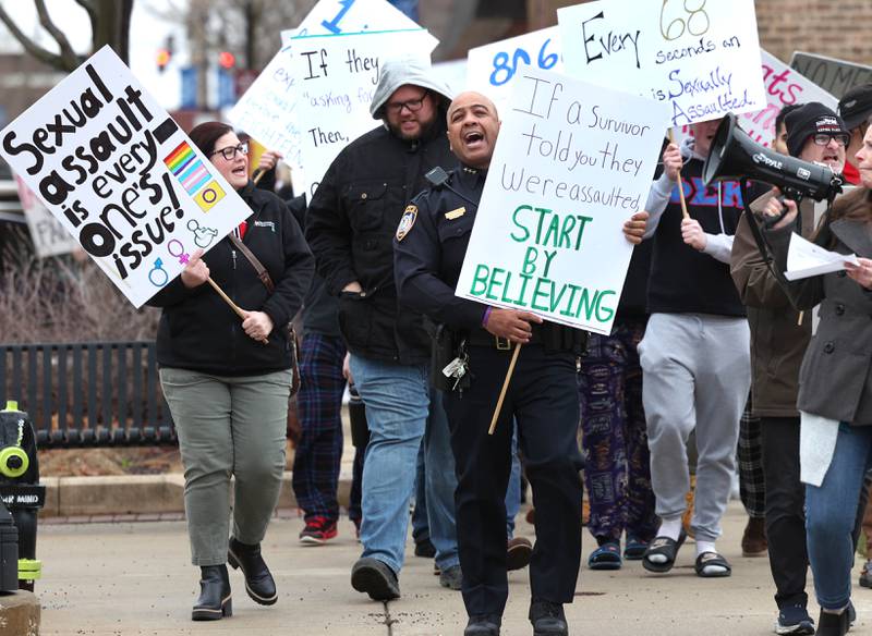 Marchers walk west on Locust street Tuesday, April 2, 2024, during Take Back the Night in DeKalb. The event, hosted by Safe Passage, is in honor of Sexual Assault Awareness Month and featured speakers and a march.