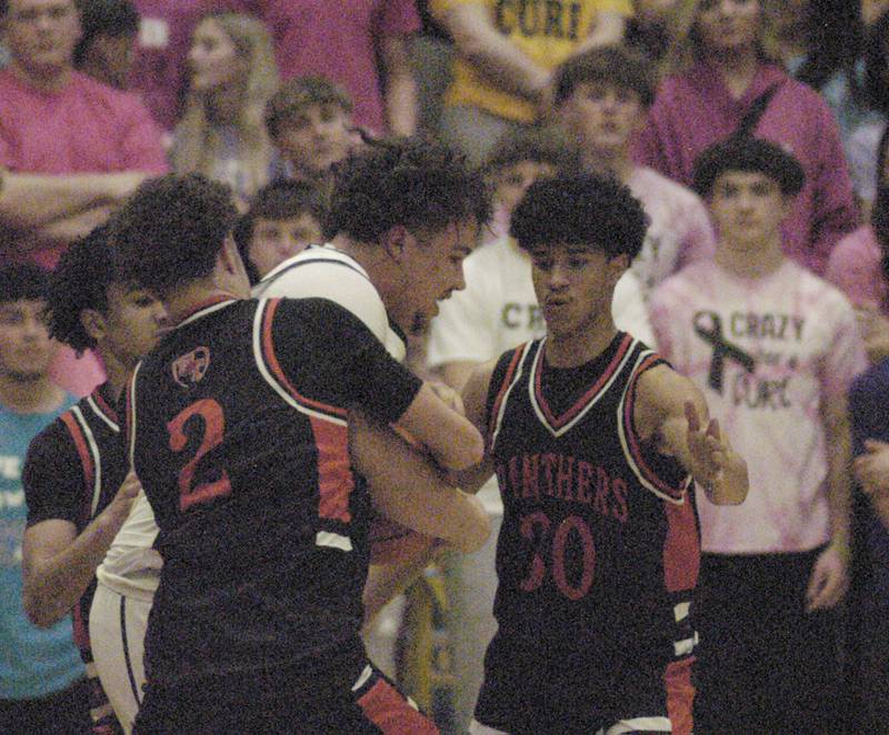 Sterling  player Maddux Osborn is wrapped up by United Township's Synceare Simons during their game Friday, Feb. 9, 2024 at Sterling High School