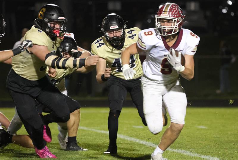 Morris' Cade Curran runs away from Sycamore's Kyle Prebil (left) and Cooper Bode during their game Friday, Oct. 18, 2024, at Sycamore High School.