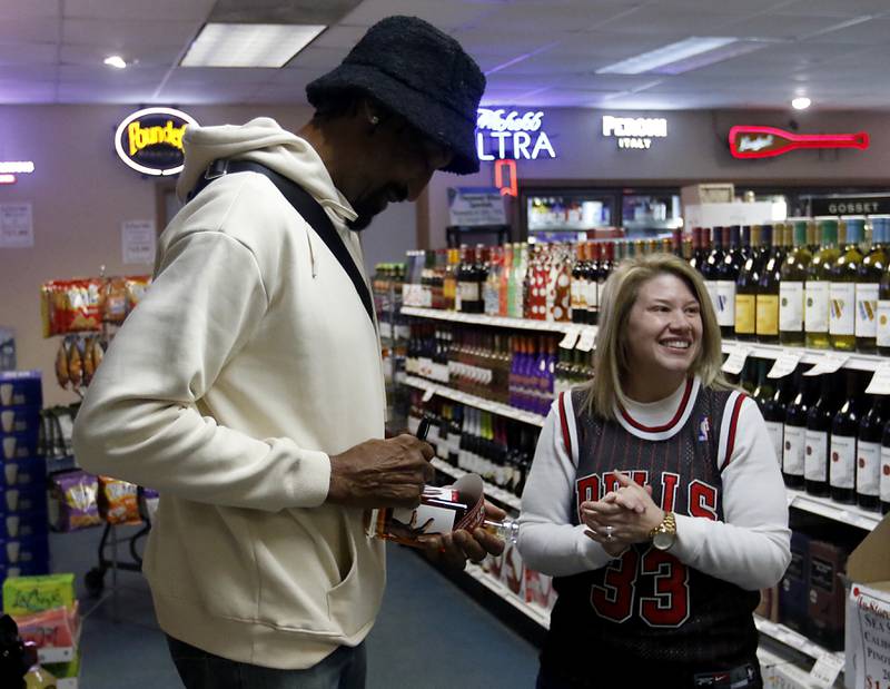 Brooke Ohl smiles as retired Chicago Bulls star Scottie Pippen signs a bottle of his Digits bourbon Thursday, Feb. 9, 2023, at The International House of Wine and Cheese, at 11302 Route 12, in Richmond.