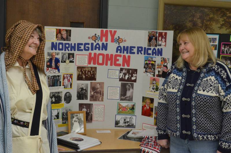 Yorkville resident Barbara Johnson, left, and sister Connie Kross of Sandwich, pose with a display chronicling suburban Norwegian-American women. In period costume, Johnson portrayed Malene Andersdatter Slogvik (1804-1868), among Norwegians who settled near what is now Leland. Johnson's presentation highlighted the monthly meeting of Sons of Norway Polar Star Chapter 5-472 at St. Olaf Lutheran Church in Montgomery.