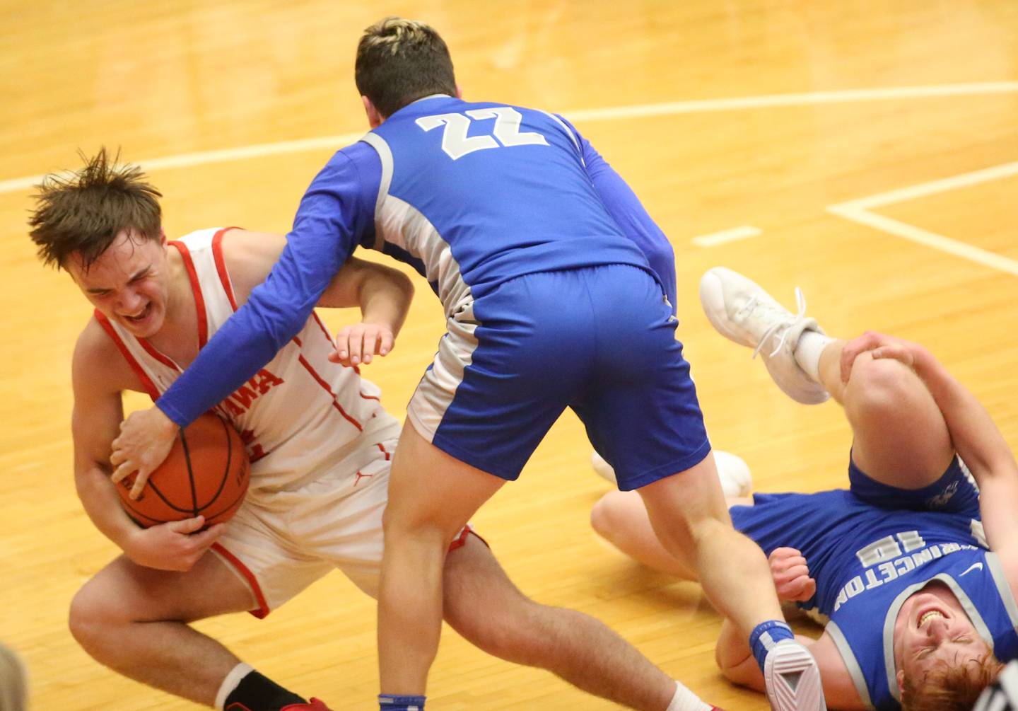 Ottawa's Huston Hart hangs on to the ball while Princeton's Evan Driscoll tries to force a jump while teammate James Starkey falls on the floor during the Dean Riley Shootin' The Rock Thanksgiving Tournament on Monday, Nov. 20, 2023 at Kingman Gym.