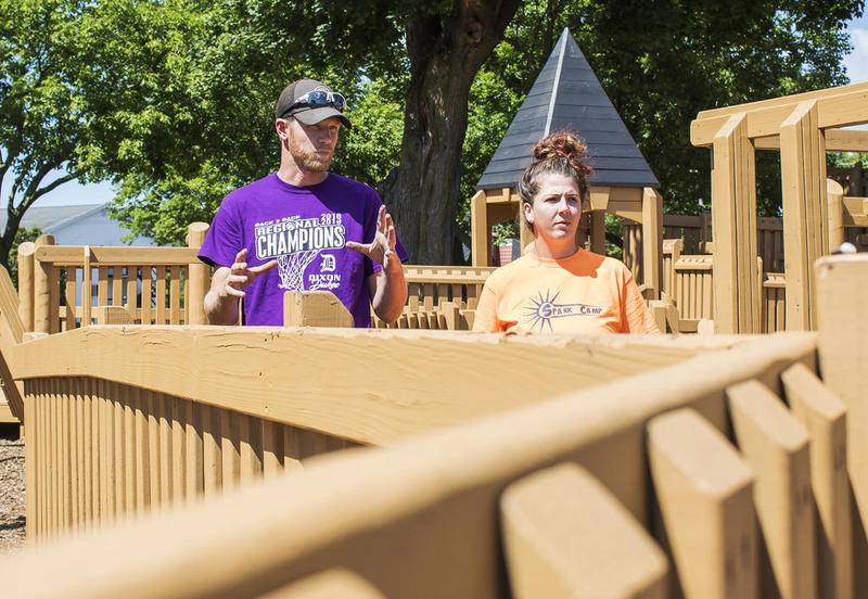 Seth Nicklaus, recreation director for the Dixon Park District, talks to Sarina Venier as the pair walks around the Wooden Wonderland playground checking for newly painted areas that might need a touch-up. The park district will reopen splash pads and parks Friday as the state moves into Phase 4 of the Restore Illinois plan.