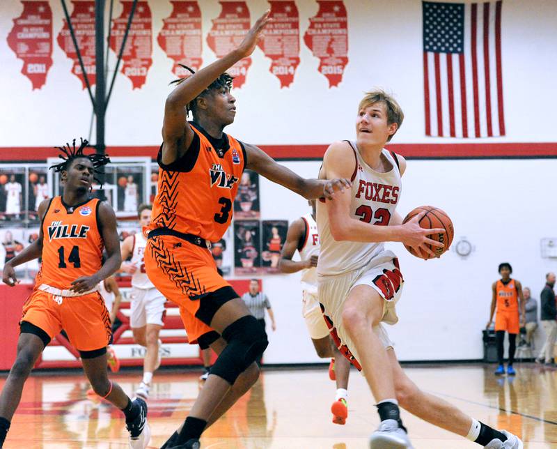 Yorkville's Jason Jakstys (right) drives and scores on Romeoville defender Adam Walker during a varsity basketball game at Yorkville High School on Friday, Jan. 19, 2024.