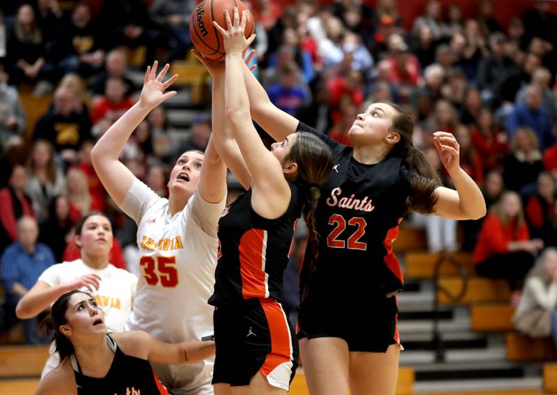 (Left to right) Batavia’s Sarah Hecht, St. Charles East’s Carmen Aguilera and St. Charles East’s Sydney Axelsen go after a rebound during a Class 4A Batavia Sectional semifinal game on Tuesday, Feb. 20, 2024.