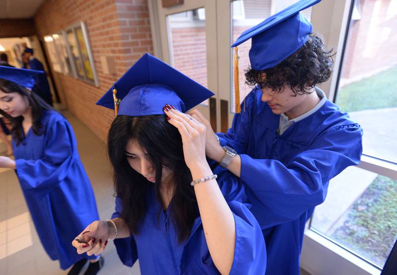 Lyons Township graduate Montserrat Pelayo of Countryside gets help with her cap from Isaiah Nedelcu of Countryside prior to their graduation ceremony Wednesday May 29, 2024.