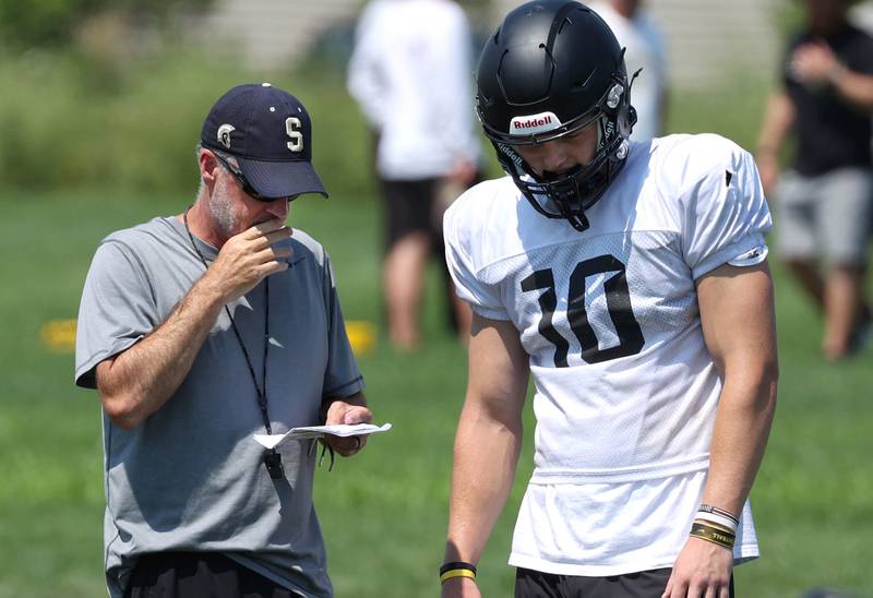 Sycamore head coach Joe Ryan gives a play to quarterback Burke Gautcher Monday, July 15, 2024, during summer football camp at Sycamore High School.